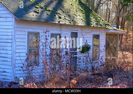 Abandonner maison blanche avec de la mousse sur le toit Banque D'Images