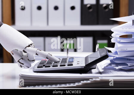 Close-up of a Robotic Hand Using Calculator Banque D'Images