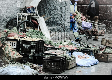 Vieille photo d'une échoppe de marché ayant des légumes en vente en face de l'entrée d'une mosquée à l'ancien souk à Casablanca, Maroc Banque D'Images