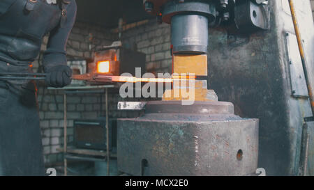 Marteau forgeron forge automatique - rouge fer chaud sur l'enclume, extreme close-up Banque D'Images