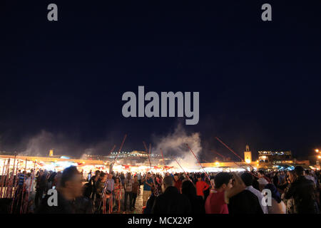 Les personnes qui pêchent avec des bâtons pour les bouteilles en plastique à la fameuse place Jemaa el Fnaa à Marrakech, Maroc Banque D'Images