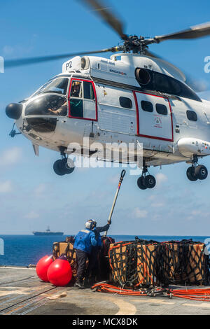 180304-N-CO914-0057 Mer de Chine du Sud (4 mars 2018) Les Marins Hayden Lien et Ty Fernandez fixer palettes de mail et l'équipement d'un SA-330J hélicoptère Puma attribué à cargaisons sèches et de munitions ship USNS Cesar Chavez (T-AKE 14) à bord de la classe Ticonderoga croiseur lance-missiles USS Lake Champlain (CG 57) lors d'un ravitaillement vertical. Le lac Champlain est opérant dans l'ouest du Pacifique dans le cadre du Groupe CarrierStrike Carl Vinson. (U.S. Photo par marine Spécialiste de la communication de masse 1re classe Nathan Carpenter/libérés) Banque D'Images