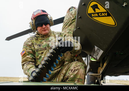 La CPS. Craig Gallegos, un armement et de l'avionique avec responsable d'entreprise, 1er Bataillon de Reconnaissance, d'attaque, 227e Régiment d'aviation, 1st Air Cavalry Brigade, Division de cavalerie, se prépare à charger un hélicoptère Apache AH-64 M230 30mm canon de la chaîne d'entraînement au tir à un aérodrome près de Grafenwoehr, Allemagne, le 6 mars 2018. Le bataillon est de fournir un appui-feu et aerial recon tout en menant dans le cadre du tir avant dynamique 18, un exercice annuel avec environ 3 700 participants de 26 nations à renforcer l'interopérabilité et d'alliances dans un environnement multinational. (U.S. Arm Banque D'Images