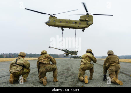 Un hélicoptère CH-47 Chinook de l'équipage désignés à la Compagnie B, 2e Bataillon de l'aviation d'appui général, 227e Régiment d'aviation de l'aviation de combat, 1ère Brigade, Division de cavalerie, des ascenseurs un obusier M777 comme chair à canon de l'équipage avec la Batterie B, l'Escadron d'artillerie, 2e régiment de cavalerie, d'observer à un aérodrome près de Grafenwoehr, Allemagne le 6 mars 2018. Les deux unités de soldats se sont rassemblés pour former et renforcer les relations tout en menant des opérations à la charge de l'élingue avant dynamique 18, un exercice annuel de l'Europe de l'armée américaine axée sur l'amélioration de l'interopérabilité de l'armée américaine, service commun et pays allié ar Banque D'Images