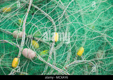 Filet de pêche en nylon vert séchage jaune avec flotteurs. Contexte photo Banque D'Images