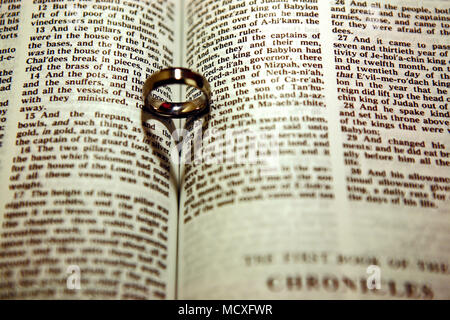 Anneau de mariage jette une ombre d'un cœur sur la bible Banque D'Images