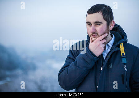 Portrait d'un jeune homme concentré en gardant la main sur le menton de décisions décision Banque D'Images