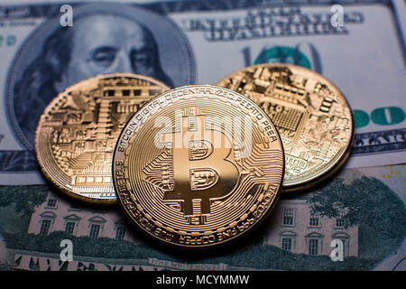 Bitcoin. Les Bitcoins en or sur un one hundred dollar bill close up Banque D'Images
