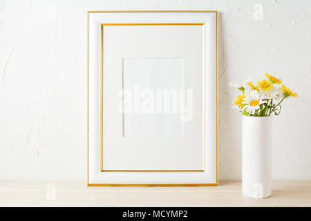 Décorées avec maquette du châssis de l'or blanc et jaune fleurs daisy vase dans le cylindre. Cadre vide maquette pour la présentation d'œuvres d'art. Frami modèle Banque D'Images