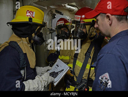 180307-N-NM917-124 Yokosuka, Japon (7 mars 2018) - Dommage Controlman 1re classe Ezio Pereira, de New York, à droite, des mémoires d'une équipe flexible prêt concernant un navire simulé blessé lors d'un conseil de l'espace principal exercice incendie à bord de l'USS Blue Ridge (CAC 19). Blue Ridge et son équipage ont maintenant entré dans une phase finale de l'entretien et la formation en vue de devenir pleinement capable de mission pour les opérations. (U.S. Photo par marine Spécialiste de la communication de masse de la Jordanie 2e classe KirkJohnson /publié) Banque D'Images