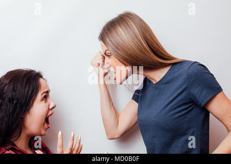 Des cris, de la haine, de la rage. Émotionnel, les jeunes font face. Moitié femelle portrait en pied. Les émotions humaines, l'expression faciale concept. Banque D'Images