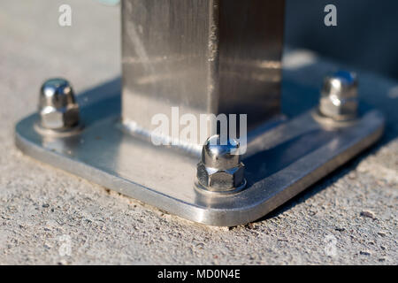 L'écrou et la rondelle joint à la structure d'acier. Fixation des supports en acier pour les fondations en béton. La saison de printemps. Banque D'Images