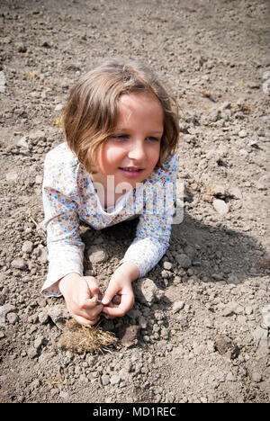 Girl laying on pendant la préparation du sol pour planter. Banque D'Images