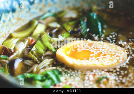 Soupe de Ramen dans un bol. Saveur riche bouillon de poulet avec la pâte de miso, grillé du poulet teriyaki, poireaux, champignons, oeufs marinés, nouilles aux oeufs, l'oignon, le chili pe Banque D'Images