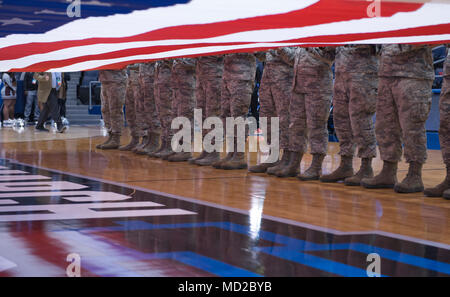 Les aviateurs de la base aérienne de Wright-Patterson, Ohio, de tenir une grande garnison, taille-drapeau américain à la moitié pendant les cérémonies de la cour arborant avant le premier tournoi NCAA quatre à l'Université de Dayton Arena à Dayton, Ohio, le 14 mars, 2018. Pendant la mi-temps du jeu des événements, le Lieutenant-général Robert McMurry Jr., gestion du cycle de vie de l'Armée de l'air, commandant du Centre a également administré le serment de l'enrôlement à l'enrôlement différé à 32 personnes. (U.S. Air Force photo par Wesley Farnsworth) Banque D'Images