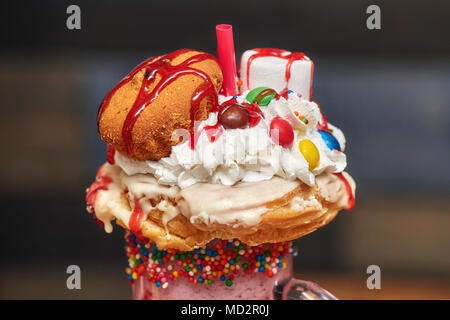 Bonbons au caramel milk shake cocktail avec de la crème fouettée, cookies, muffins et autres friandises, gros plan Banque D'Images