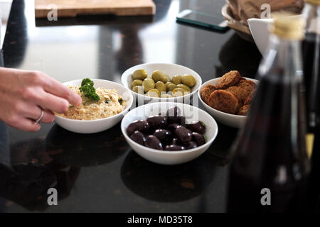 L'hoummos classic, noir et vert olive et falafel,Groupe d'amis de désinvolture snacking sur une sélection de produits alimentaires tout en rire et s'amuser. Banque D'Images