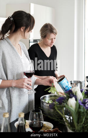 Groupe d'amis de désinvolture snacking sur une sélection de produits alimentaires tout en rire et s'amuser. Banque D'Images