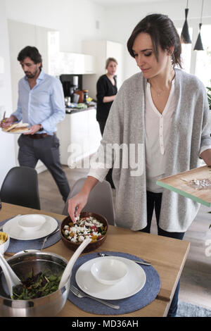 L'ajout de fetta sur saladGroup mixtes à des amis de désinvolture snacking sur une sélection de produits alimentaires tout en rire et s'amuser. Banque D'Images