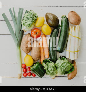 Mise à plat des légumes frais située dans l'ordre sur le bois blanc. Banque D'Images