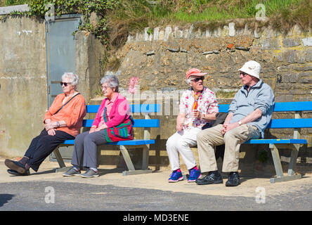 Bournemouth, Dorset, UK. 18 avril 2018. Météo France : belle chaude journée ensoleillée à plages de Bournemouth avec un ciel bleu et soleil ininterrompue, en tant que visiteurs, chef de la mer pour profiter de la journée la plus chaude de l'année jusqu'à présent. Hauts assis sur des bancs sur la promenade profitant du soleil. Mini vague. Credit : Carolyn Jenkins/Alamy Live News Banque D'Images