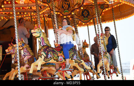 Brighton UK 18 avril 2018 - Fun sur le carrousel dans le temps ensoleillé chaud sur le front de mer de Brighton aujourd'hui . La prévision est pour plus de temps chaud et ensoleillé au cours des prochains jours avec des températures atteignant 25 degrés dans certaines régions du sud-est Crédit : Simon Dack/Alamy Live News Banque D'Images