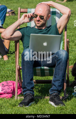 Londres, Royaume-Uni. 18 avril 2018. Le bureau mobile - une journée ensoleillée dans Green Park met en valeur les touristes et les employés de bureau pour profiter de la première véritable journée chaude de l'année. Crédit : Guy Bell/Alamy Live News Banque D'Images