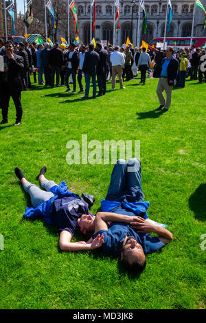 Météo France : jeune couple s'endormir dans le bain de soleil dans la place du Parlement à Londres, indifférent à l'énorme et très fort de protestation anti-Modi autour d'eux, sur la journée la plus chaude de l'année jusqu'à présent, le mercredi 18 avril 2018 Banque D'Images