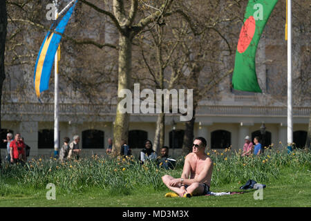 Londres, Royaume-Uni. 18 avril 2018. Un homme de soleil dans le printemps chaud météo à St James' Park sur un jour où la température atteignait 25 degrés à Londres. Les indicateurs ont été affichées sur le Mall pour l'arrivée des chefs de gouvernement du Commonwealth. Date de la photo : le mercredi, 18 avril, 2018. Photo : Roger Garfield/Alamy Live News Banque D'Images