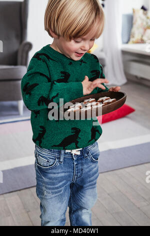 Jeune garçon maintenant la plaque de cookies Banque D'Images