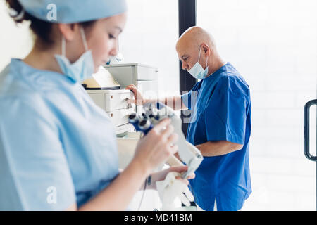 Dentiste et l'infirmière qui travaille au bureau de dentiste Banque D'Images