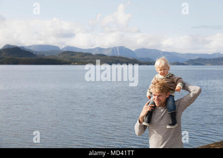 Man giving son épaule ride par fjord, Aure, More og Romsdal (Norvège) Banque D'Images