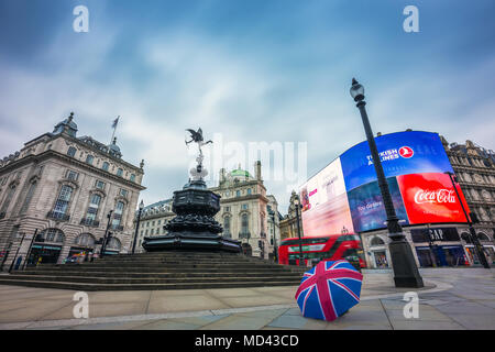 Londres, Angleterre - 03.18.2018 : Union Jack iconique parasol à la Piccadilly Circus vide le matin avec des bus à impériale rouge en mouvement Banque D'Images