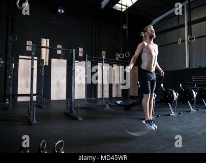 L'exercice de l'homme dans un gymnase, avec corde à sauter de vitesse Banque D'Images