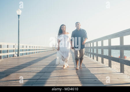 Couple en train de marcher le long du quai, se tenir la main, Seal Beach, California, USA Banque D'Images