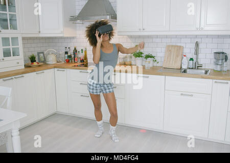 Femme à lunettes VR dancing in kitchen Banque D'Images