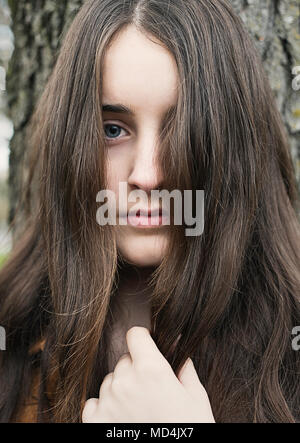 Une adolescente (13 ans) avec des cheveux longs, regardant la caméra. Banque D'Images