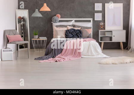 Deux couvertures rose et gris jeté sur un lit avec plein d'oreillers debout dans l'intérieur de chambre à coucher Banque D'Images