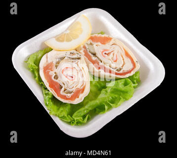 Sandwiches au saumon sur les feuilles de salade verte et de citron sur un plateau blanc Banque D'Images