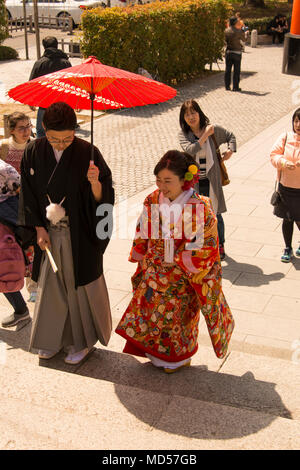 En couple traditionel japonais et monter des marches du sanctuaire à l'abri d'un parasol Banque D'Images