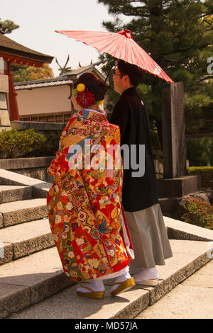 En couple traditionel japonais et monter des marches du sanctuaire à l'abri d'un parasol Banque D'Images