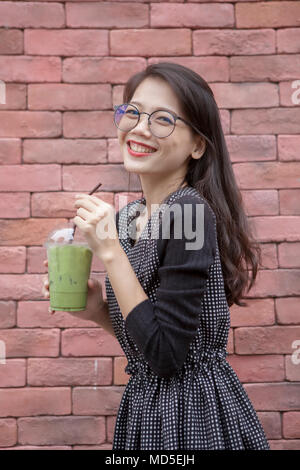 Jeune femme asiatique et verres de glace boissons Thé vert dans la main Banque D'Images
