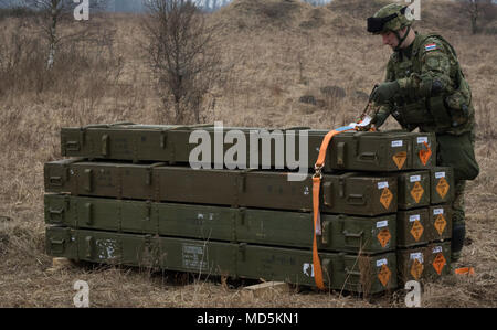 Un soldat de l'artillerie croate affecté à la batterie volcan unstraps une pile de roquettes pour commencer à préparer l'eux d'être apprêtés et charger dans son équipe Vulkan M-92, les lance-roquettes multiples, tandis que la batterie participe au 3e Escadron, 2e régiment de cavalerie, à l'exercice de tir réel de l'escadron une gamme près de la zone d'entraînement Bemowo Piskie, Pologne, le 23 mars 2018. Ces soldats sont une partie de l'unique groupe de combat multinationales, composé de États-Unis, Royaume-Uni, croate et soldats roumains qui servent avec la 15e Brigade mécanisée polonaise comme une force de dissuasion dans le nord-est de la Pologne à l'appui o Banque D'Images