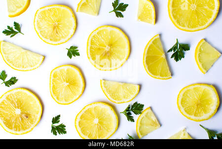 Les tranches de citron et feuilles de persil sur fond blanc Banque D'Images