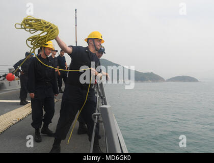 180327-N-PN963-0026 HONG KONG (27 mars 2018) Maître de Manœuvre 2ème Brian Mello de Flemington, N.J., lance une ligne de messenger à bord de la classe Arleigh Burke destroyer lance-missiles USS Sterett (DDG 104) dans le cadre d'un service au port. Sterett est à Hong Kong à l'expérience de la ville la richesse de la culture et l'histoire comme missiles de l'poursuit son déploiement avec le groupe expéditionnaire Wasp comme un actif multi-mission dans la région Indopacifique. (U.S. Photo par marine Spécialiste de la communication de masse 2e classe Richard L.J. Gourley/libérés) Banque D'Images