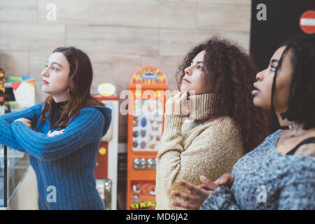 Trois jeunes femmes à regarder quelque chose d'intérieur multiethnique - commande de l'alimentation, le choix, l'alimentation et boissons concept Banque D'Images