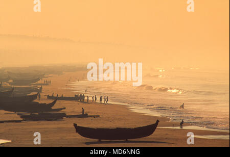 Kerala, Inde ; bateaux de pêche sur la plage à l'aube. La pêche traditionnelle dans le Kerala est de plus en plus menacée par la pêche en usine. Banque D'Images