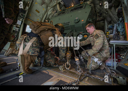 Les cadres supérieurs de l'Armée de l'air Airman Brandon Lowe (droite), arrimeur avec le 9e Escadron d'opérations spéciales, et le sergent du Corps des Marines. Jeffery Hale (à gauche), un lanceur chef avec Kilo Batterie, 2e Bataillon, 14e Régiment de Marines, vers le bas de la chaîne d'un Marine Corps un M142 Système de roquettes d'artillerie à grande mobilité (HIMARS) sur une armée de l'air MC-130 à Fort Campbell, Kentucky, le 29 mars 2018. Les Marines du kilo de batterie Fort Campbell à Dugway Proving Grounds, Utah, où ils ont débarqué et a tiré quatre missiles HIMARS, démontrant une capacité unique qui permettra aux commandants plus d'options pour faire face aux menaces lorsqu'oth Banque D'Images