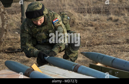 Un soldat affecté à l'artillerie croate batterie volcan son équipe de préparer des fusées pour être chargés dans leur Vulkan M-92, les lance-roquettes multiples, tandis que la batterie participe à la nuit de l'itération 3e Escadron, 2e régiment de cavalerie, à l'exercice de tir réel de l'escadron une gamme près de la zone d'entraînement Bemowo Piskie, Pologne, le 25 mars 2018. Ces soldats sont une partie de l'unique groupe de combat multinationales, composé de États-Unis, Royaume-Uni, croate et soldats roumains qui servent avec la 15e Brigade mécanisée polonaise comme une force de dissuasion dans le nord-est de la Pologne à l'appui de l'OTAN Forwar renforcée du Banque D'Images