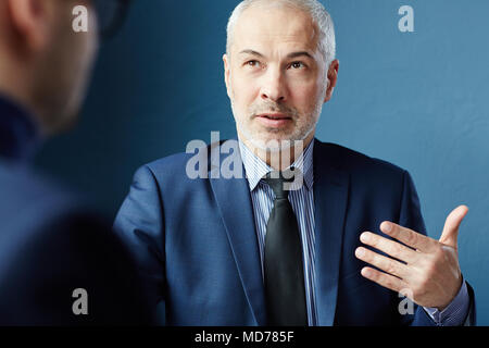Portrait of mature aux cheveux gris Caucasian businessman discuter de nouveaux objectifs de l'entreprise avec son partenaire d'affaires Banque D'Images